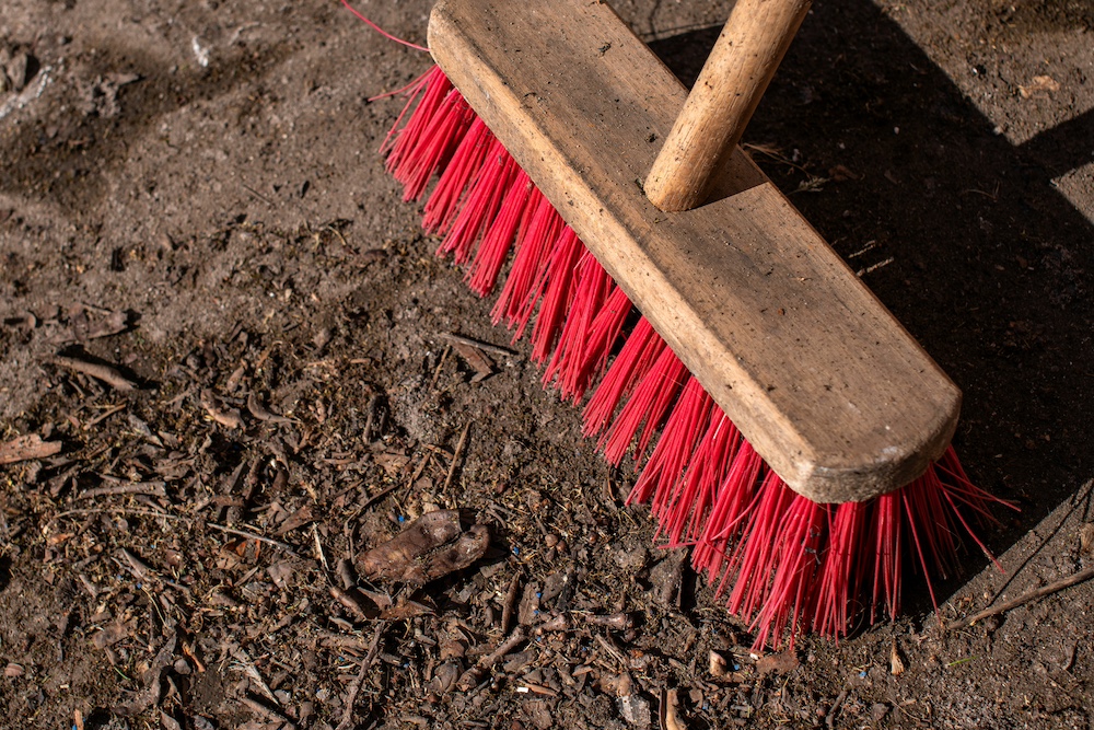 Wooden broom with red bristles 