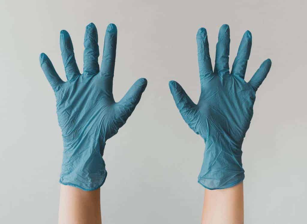 Hands wearing blue latex gloves.