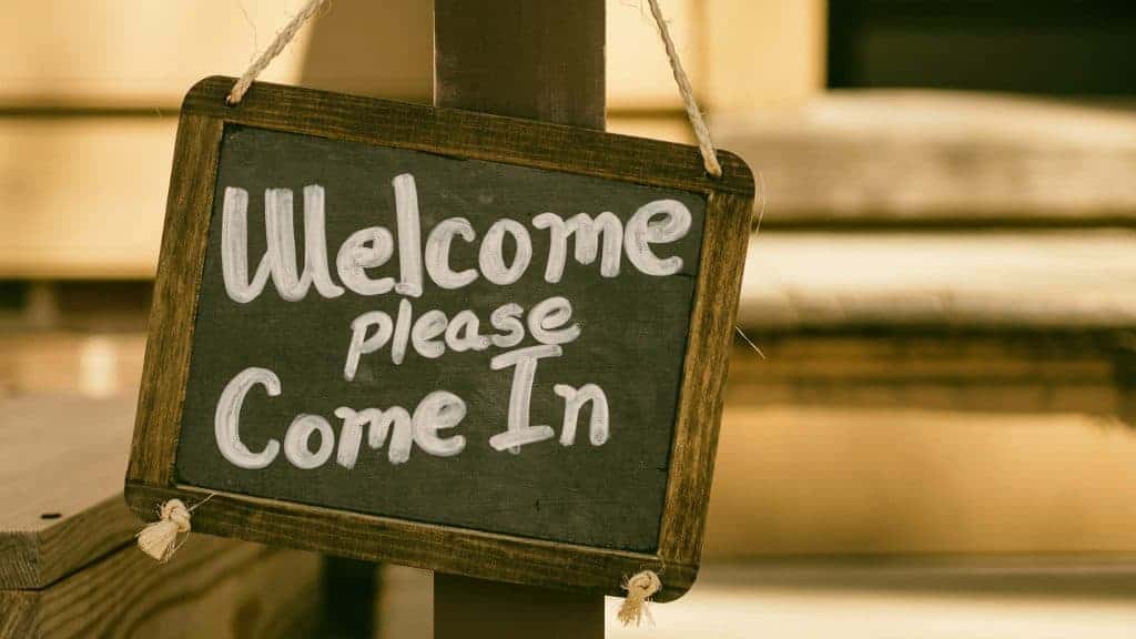 A chalkboard sign that says "Welcome Please Come In"