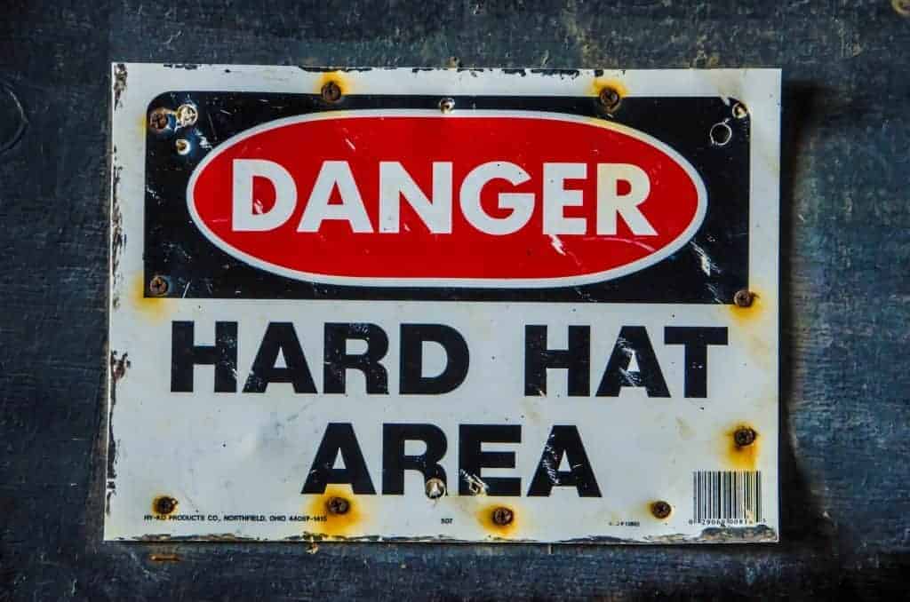 Weathered sign that says "Danger: Hard Hat Area"