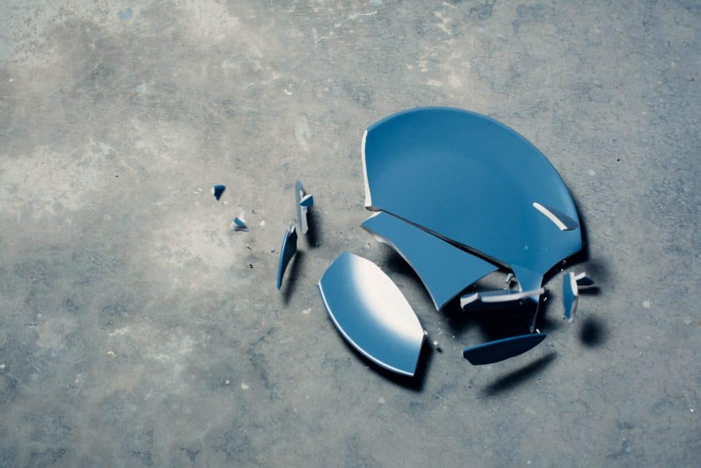 broken blue plate on a grey floor