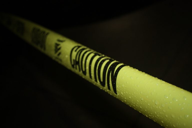 caution tape stretched across blackness