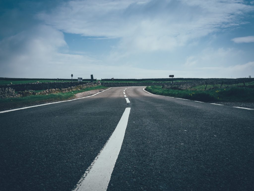 An image of a road leading through fields to a wide horizon.