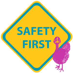 A bright yellow diamond sign says "safety first in teal. A Magenta cartoon turkey stands in front of the sign.