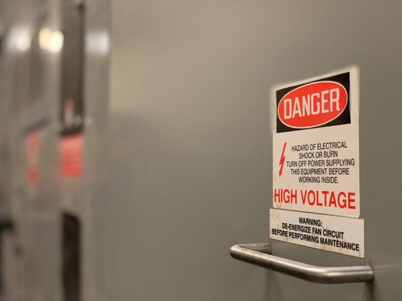 Sign reads "Danger - Hazard of electrical shock or burn. Turn off power supplying this equipment before working inside. High voltage."