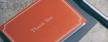 An image of a pen with a red thank you note.