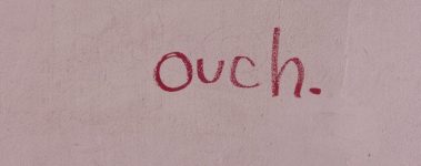 Pink note paper with the word "ouch' written in red.